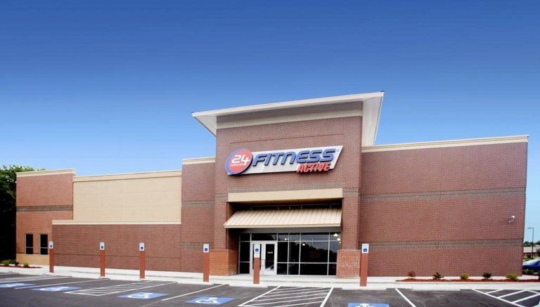 A fitness store with a parking lot in front of it