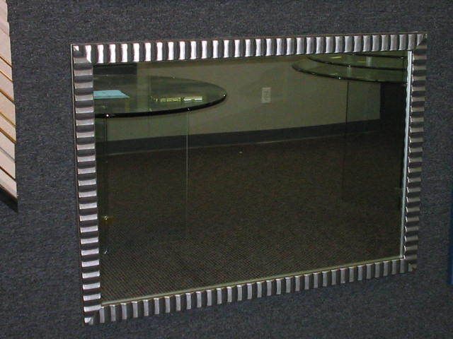 A mirror with a striped frame is hanging on a wall