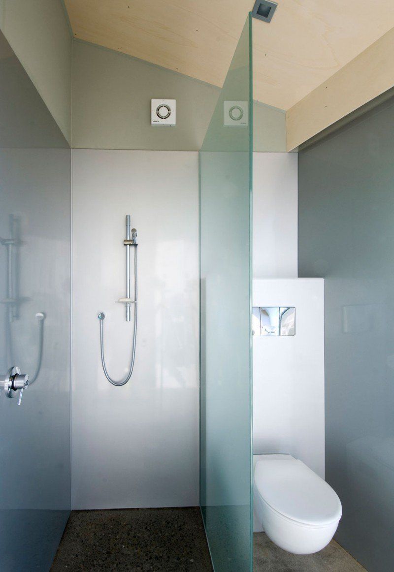 A bathroom with a toilet and a shower with a glass wall