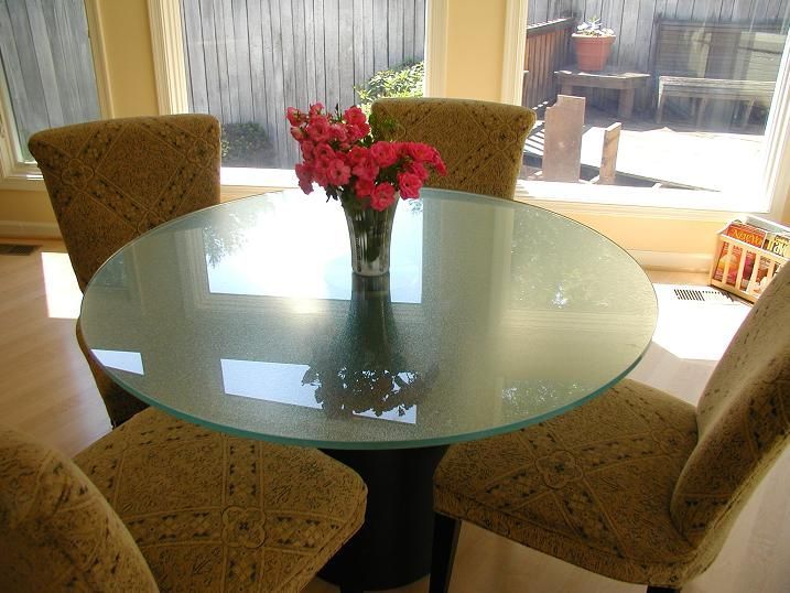 A glass table with a vase of flowers on it