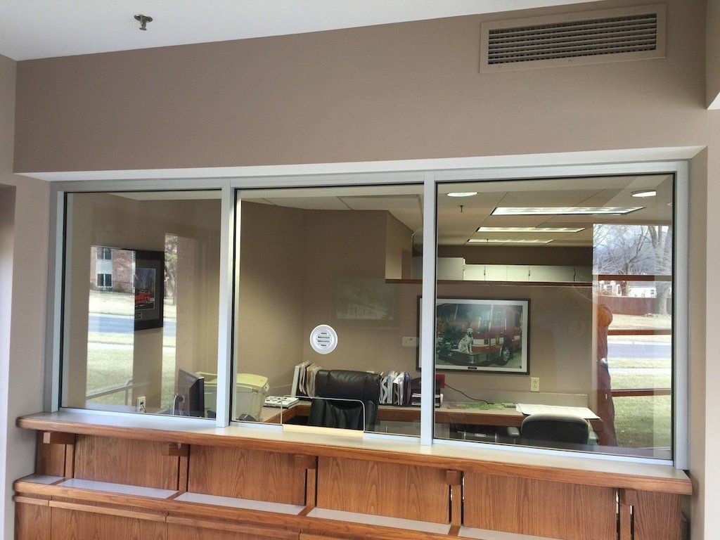 A large window in an office with a picture on the wall