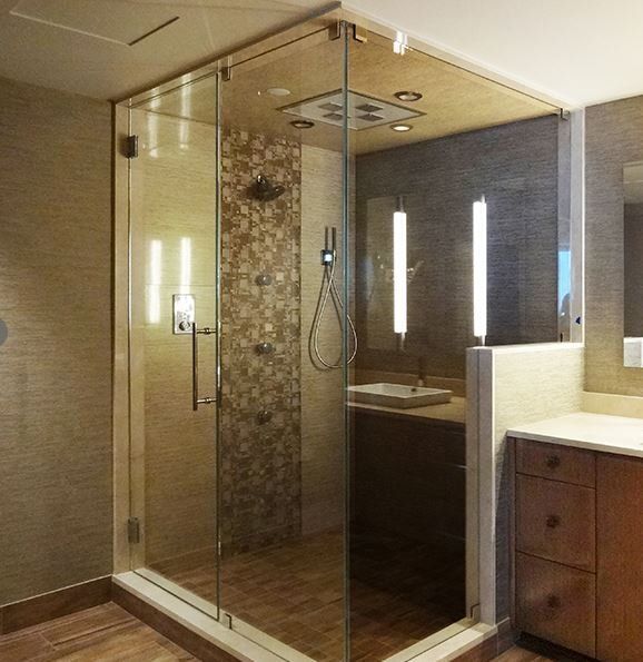 A bathroom with a walk in shower and a sink