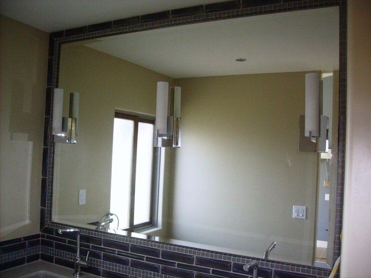 A bathroom with a large mirror and a sink