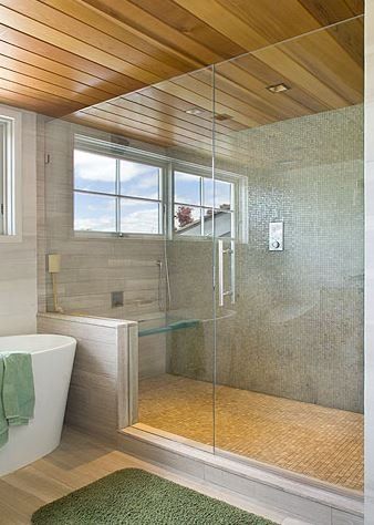 A bathroom with a bathtub and a walk in shower with a glass door.