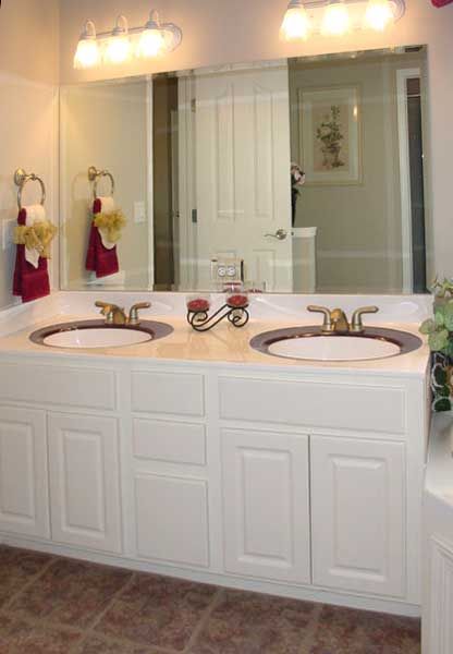 A bathroom with two sinks and a large mirror
