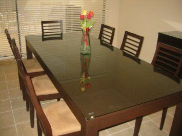 A dining room table with a vase of flowers on it