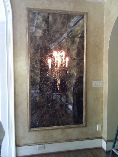 A large mirror with a picture of a chandelier in it