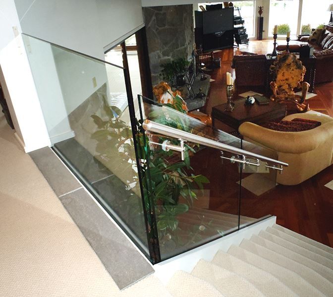 Stairs leading up to a living room with a glass railing