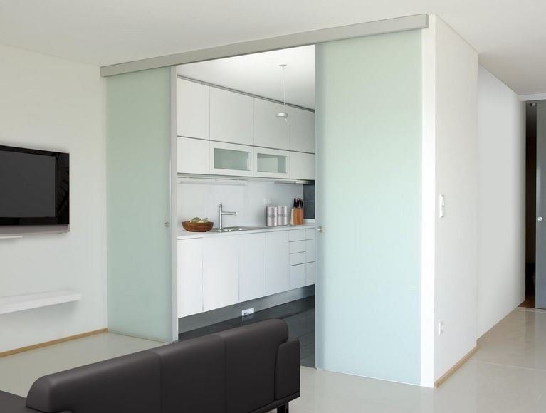 A living room with a sliding glass door leading to a kitchen