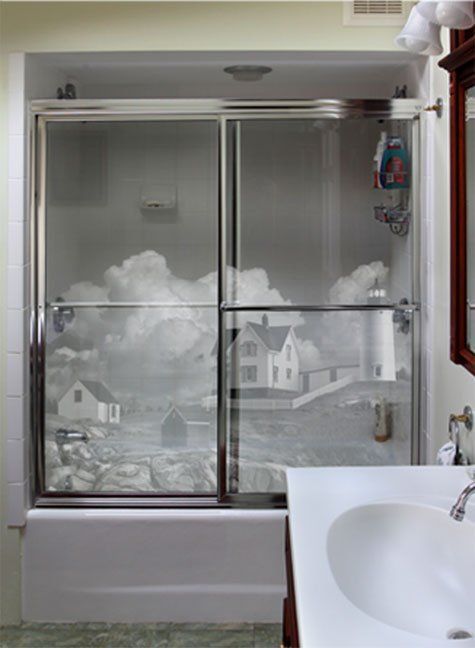 A bathroom with a sliding glass shower door and a sink