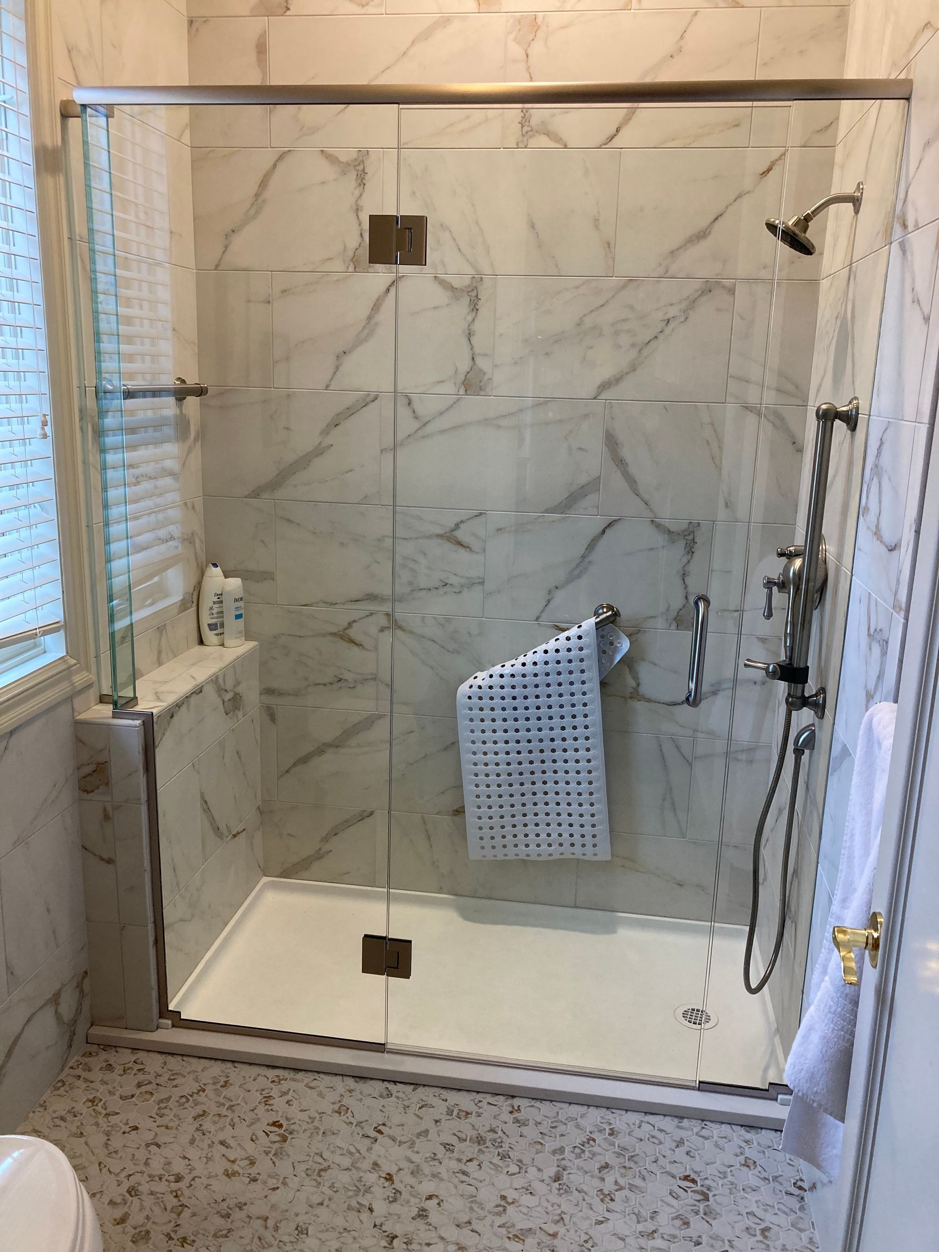 A bathroom with a walk in shower and a toilet.