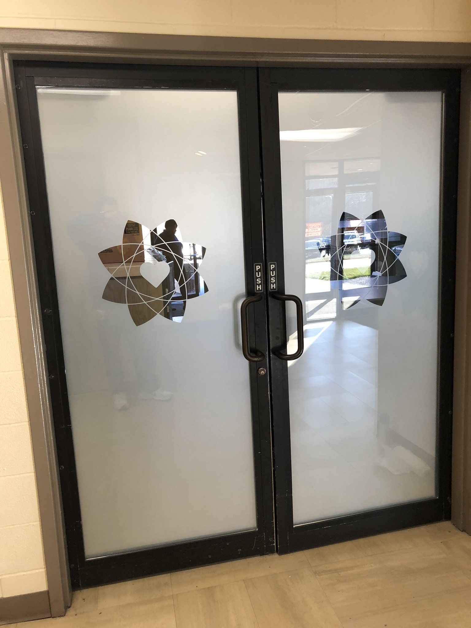 A pair of glass doors with a logo on them.