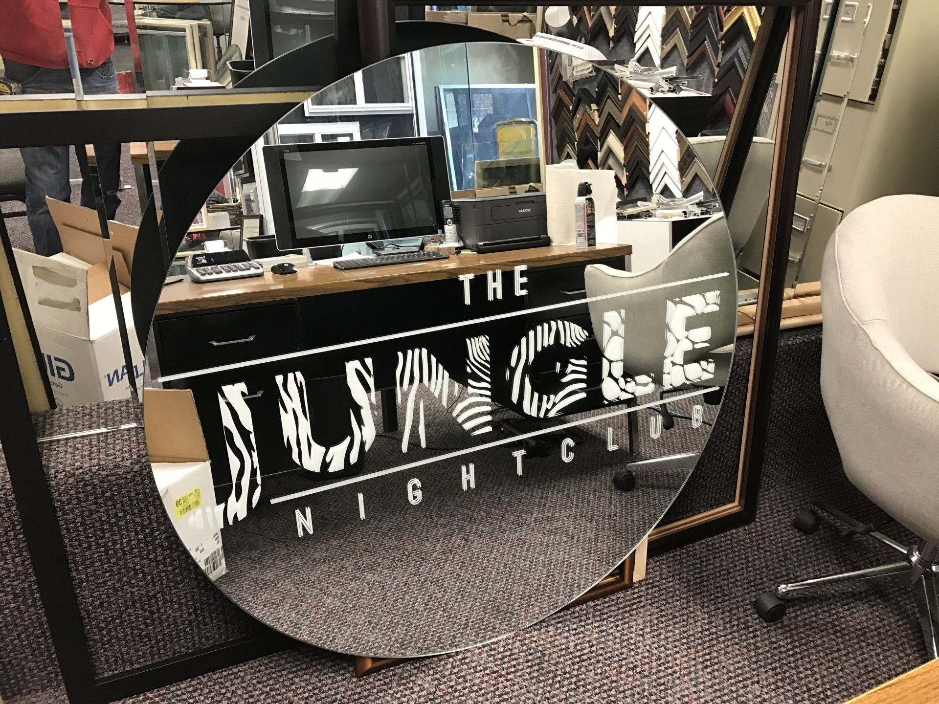 A round mirror with the words the jungle night club on it