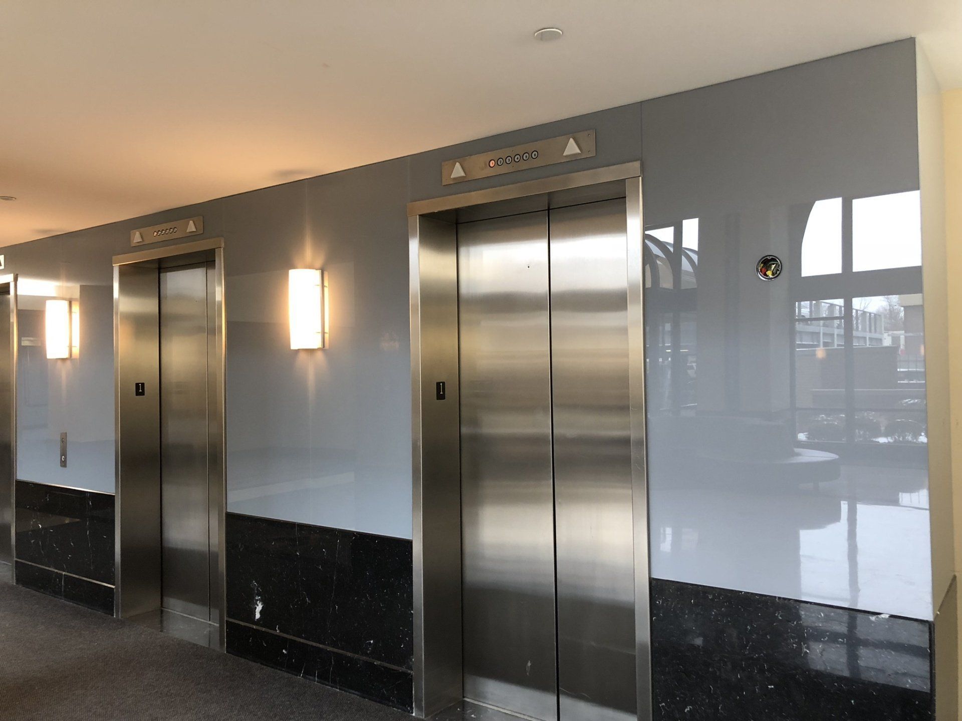 There are two elevators in the hallway of a building.