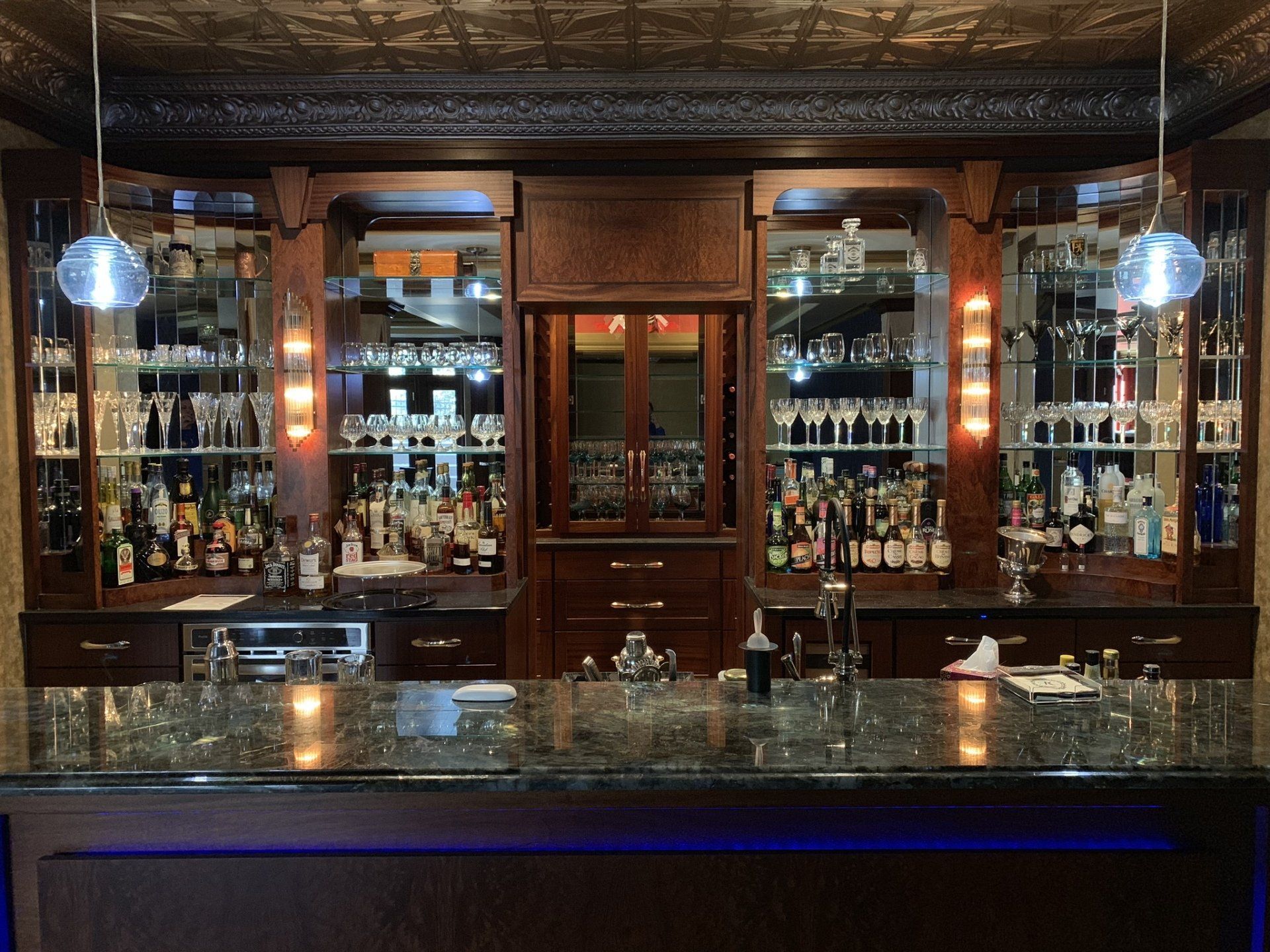 A bar with a lot of bottles and glasses on it