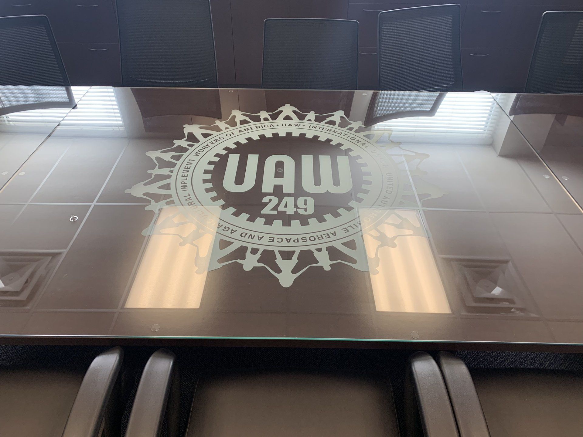 A glass table with a logo on it that says uaw 249
