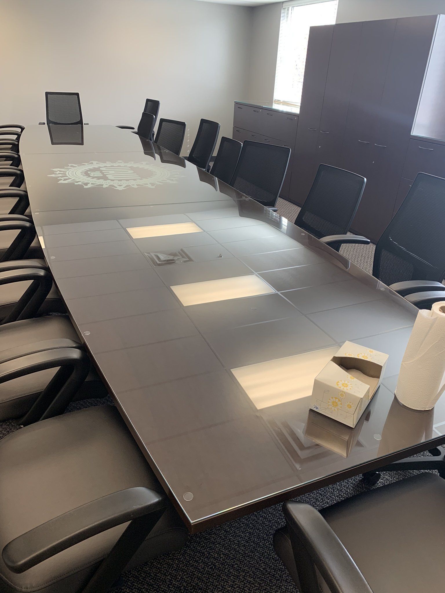A conference room with a long table and chairs.