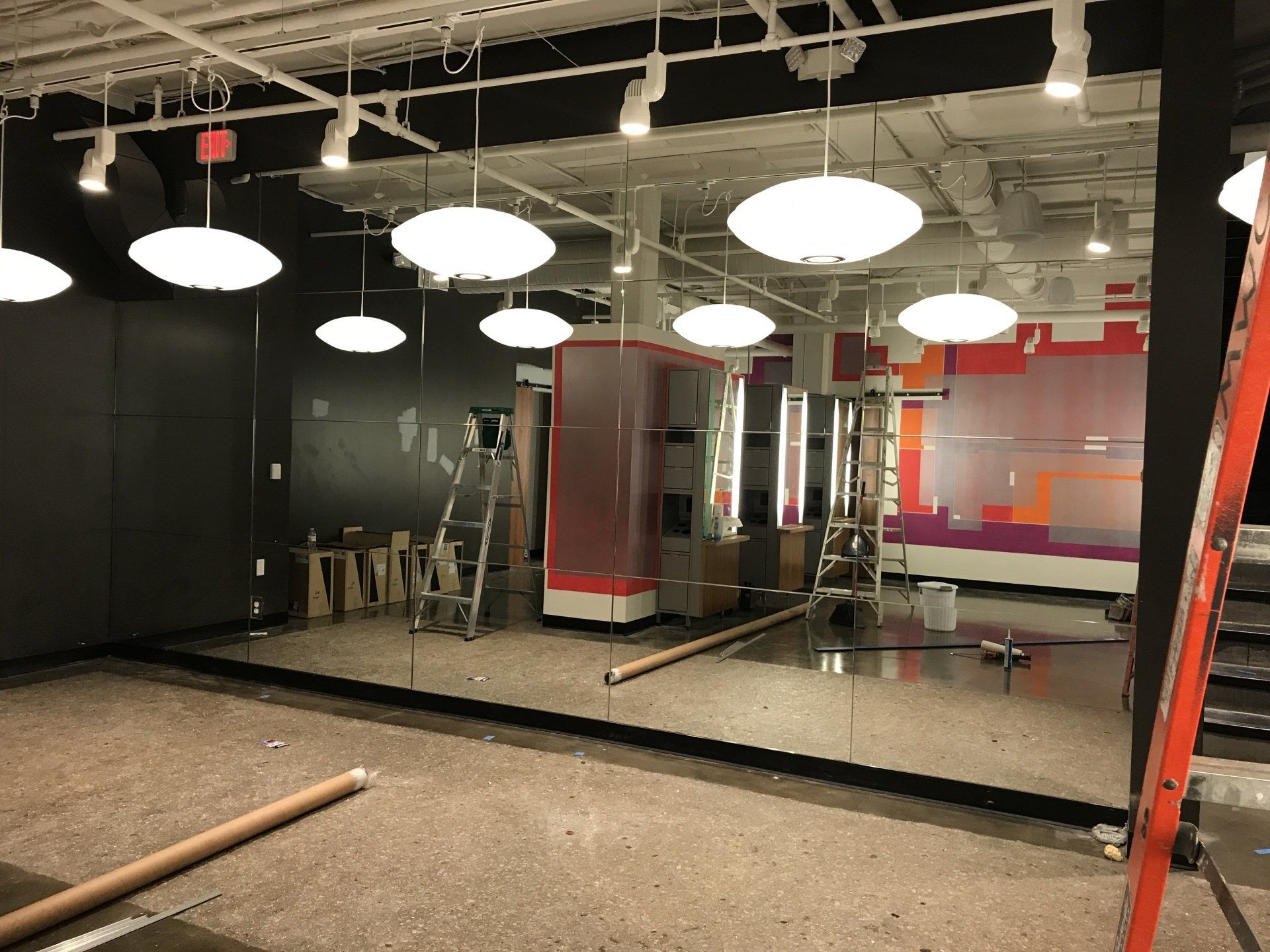 A large room with a lot of mirrors and lights hanging from the ceiling.