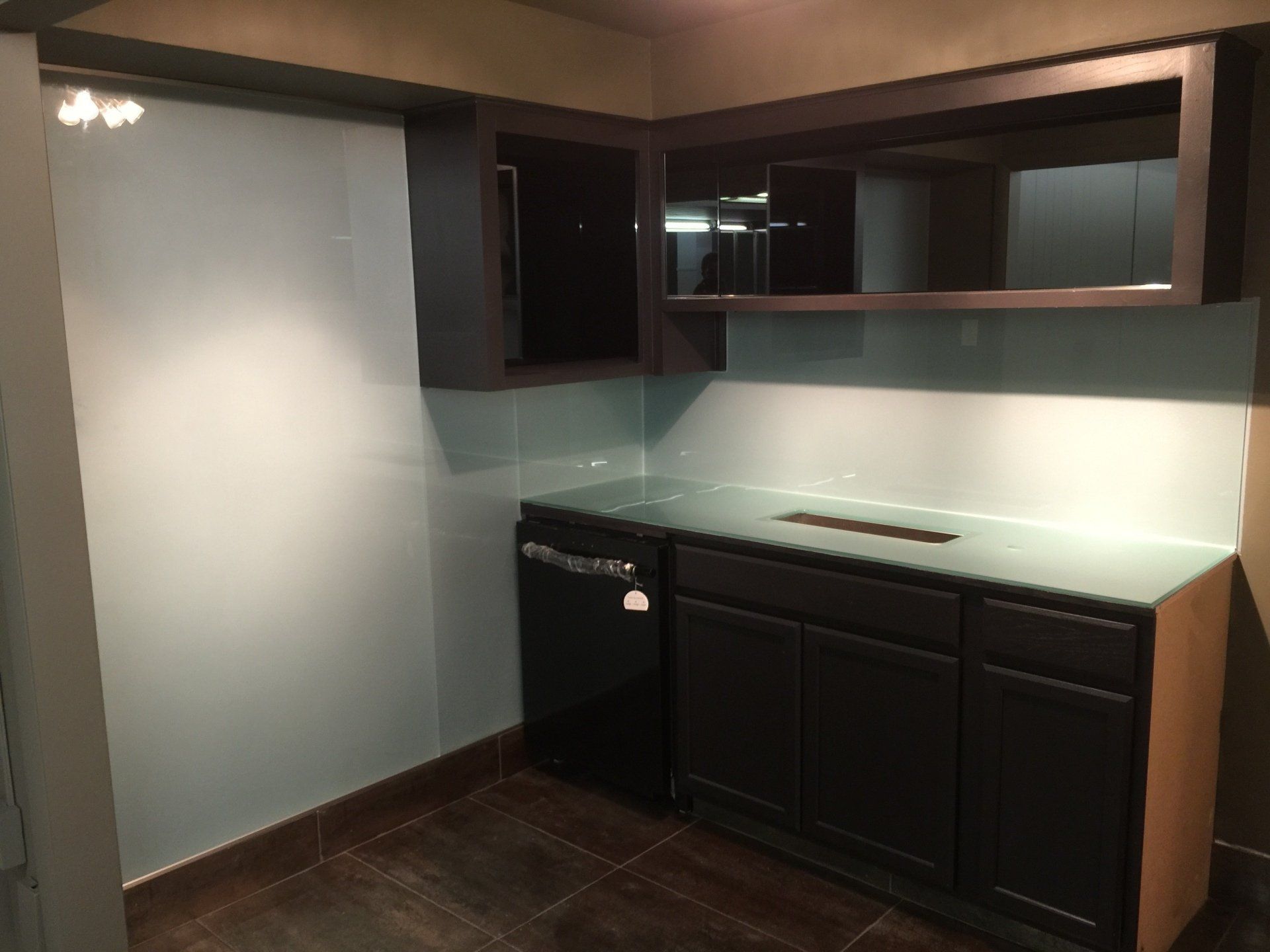 A kitchen with black cabinets and a white counter top
