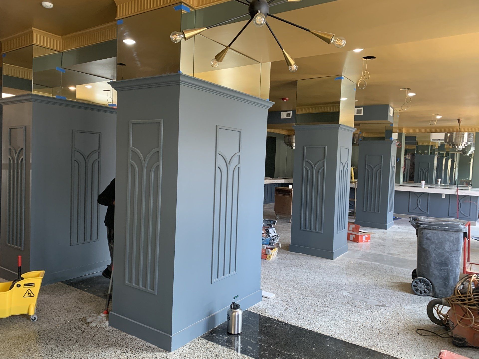 A large room with a lot of columns and a ceiling fan.