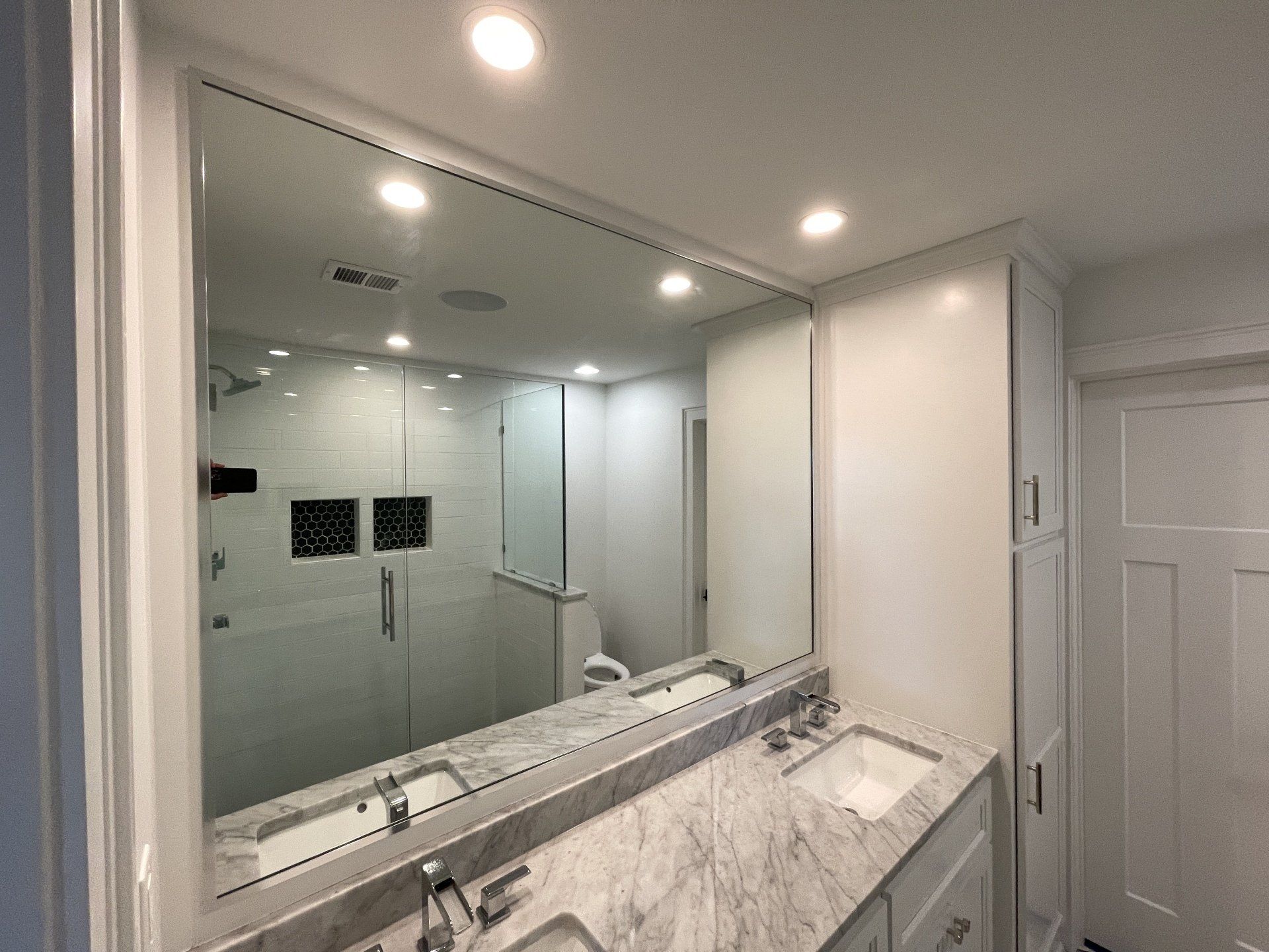 A bathroom with two sinks and a large mirror.