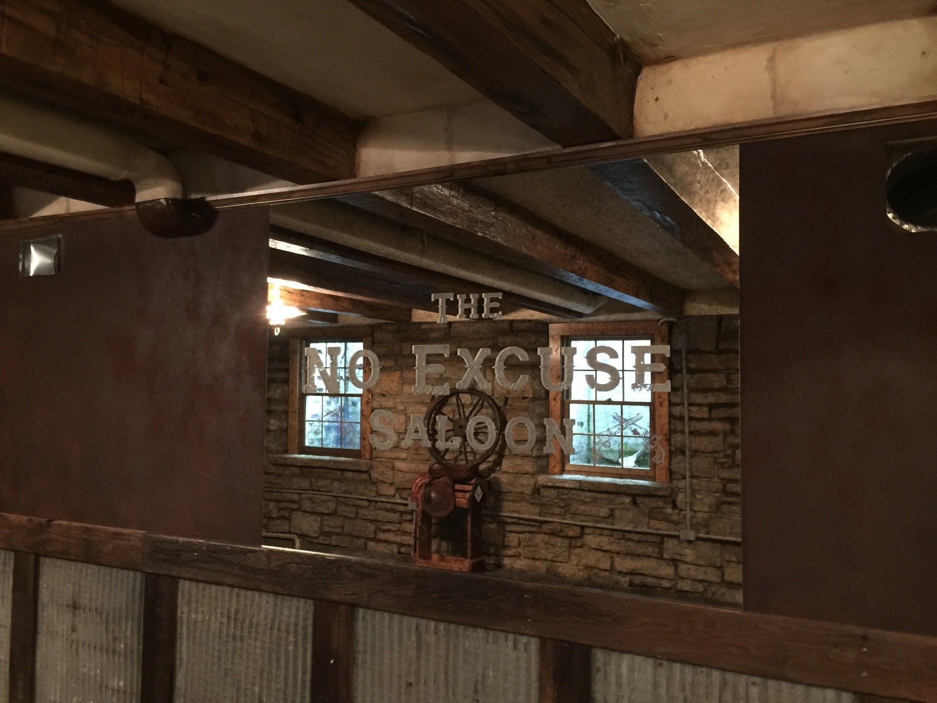 A mirror in a room that says the excuse saloon