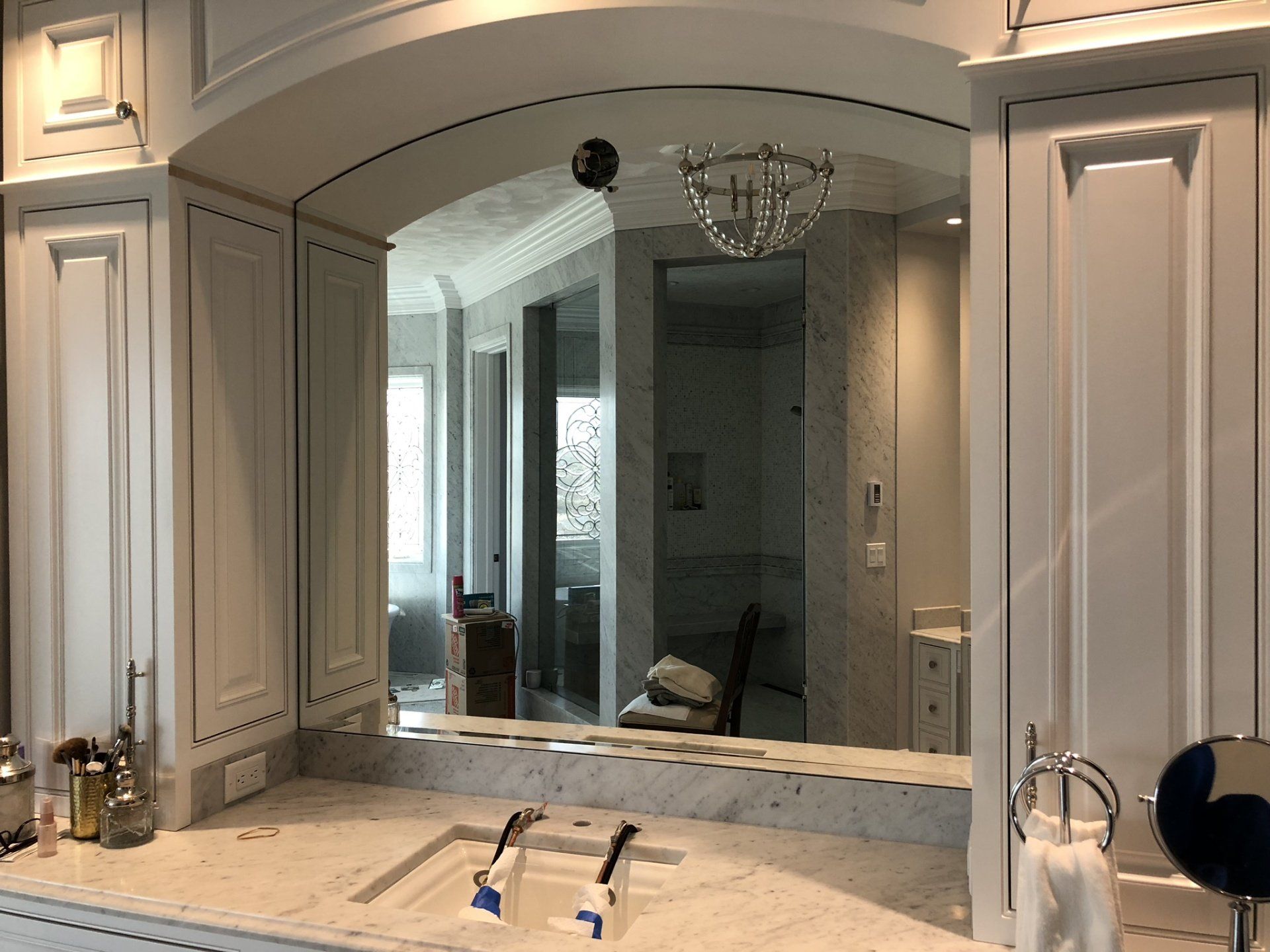 A bathroom with a sink and a large mirror.