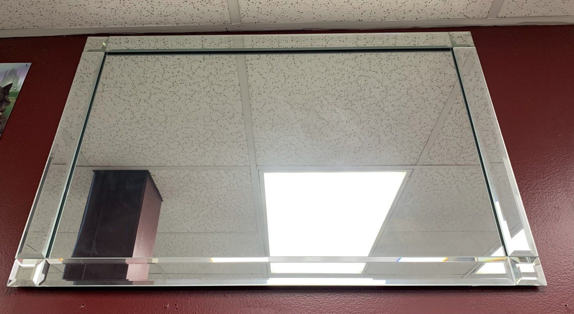 A large mirror is sitting on a red wall