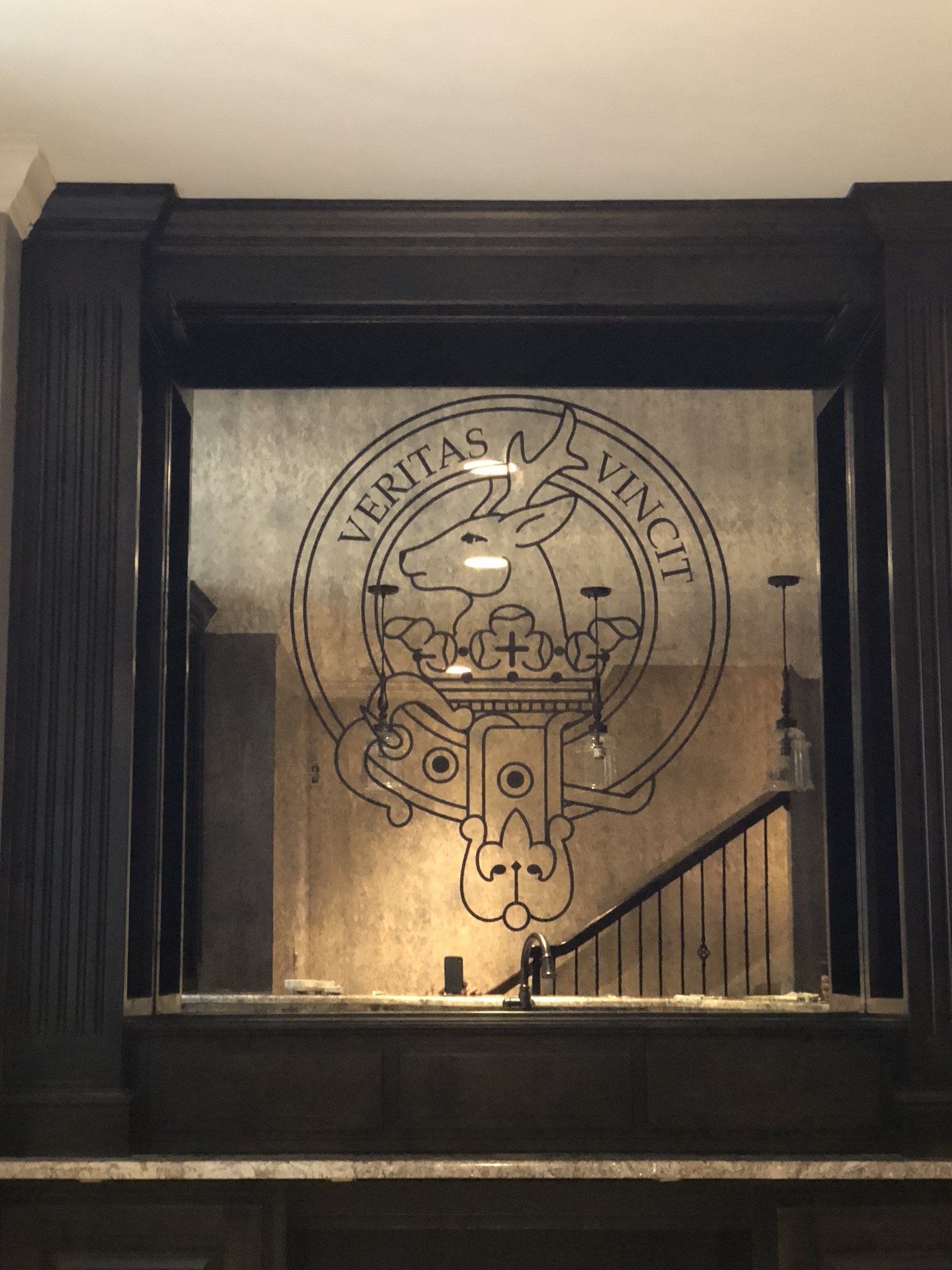 A mirror with a crest on it that says veritas vincit