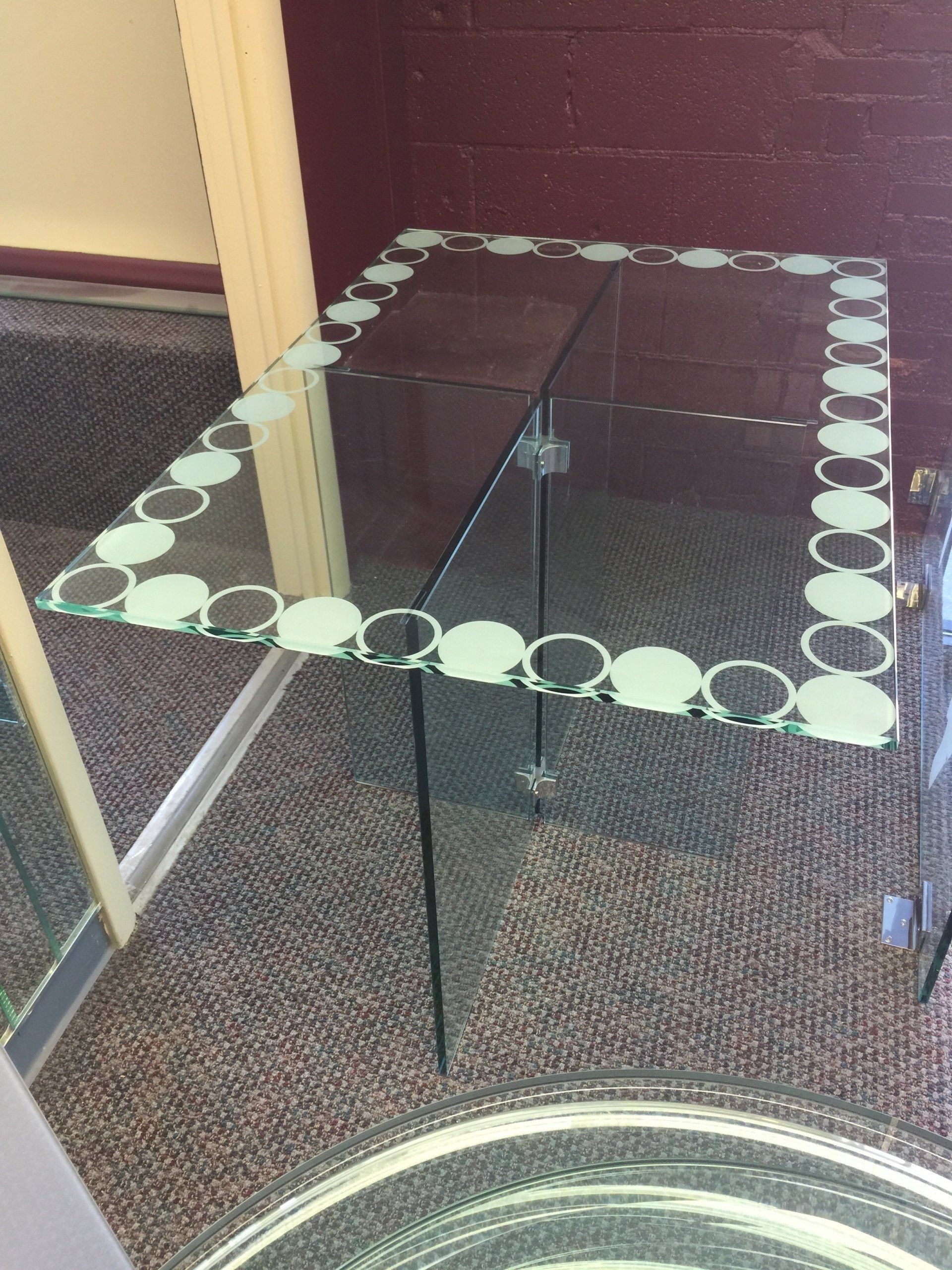 A glass table with circles on it is in front of a mirror