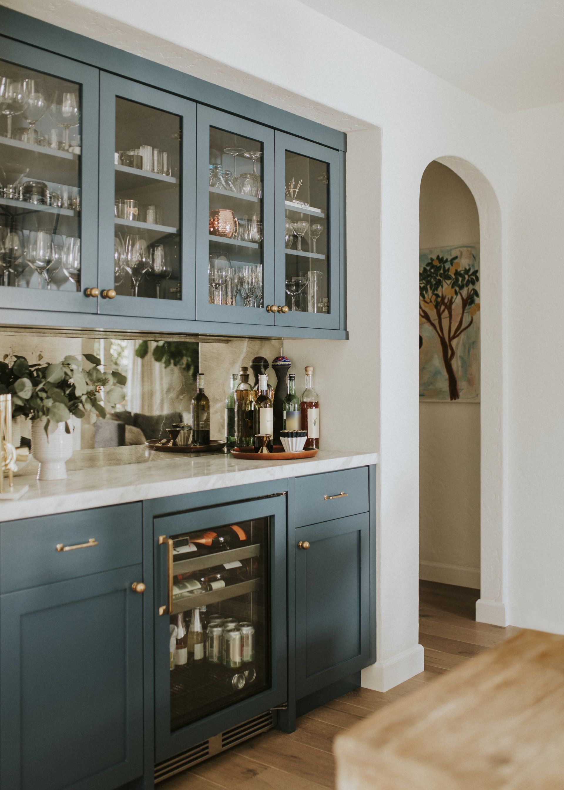 A kitchen with blue cabinets and a wine cooler.