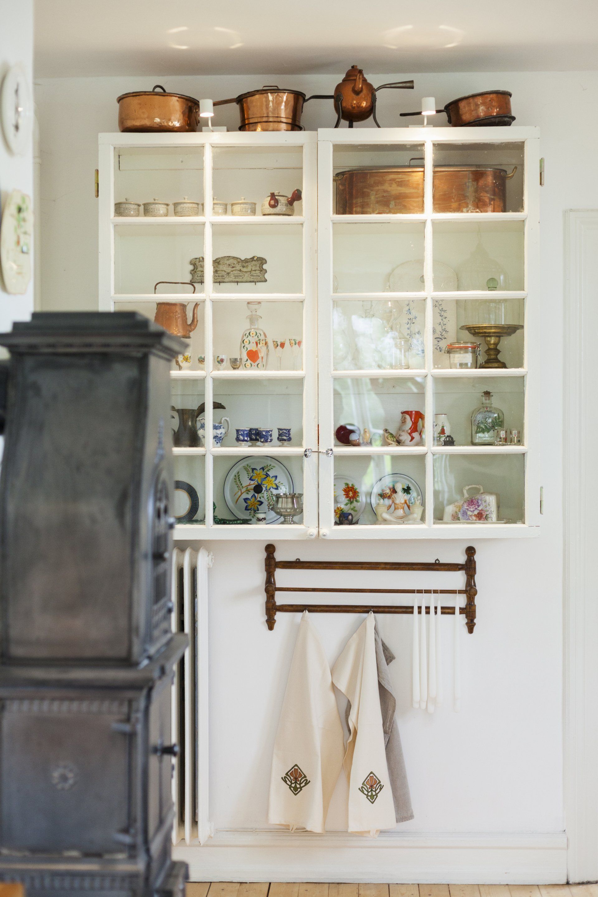 A kitchen with white cabinets and copper pots and pans