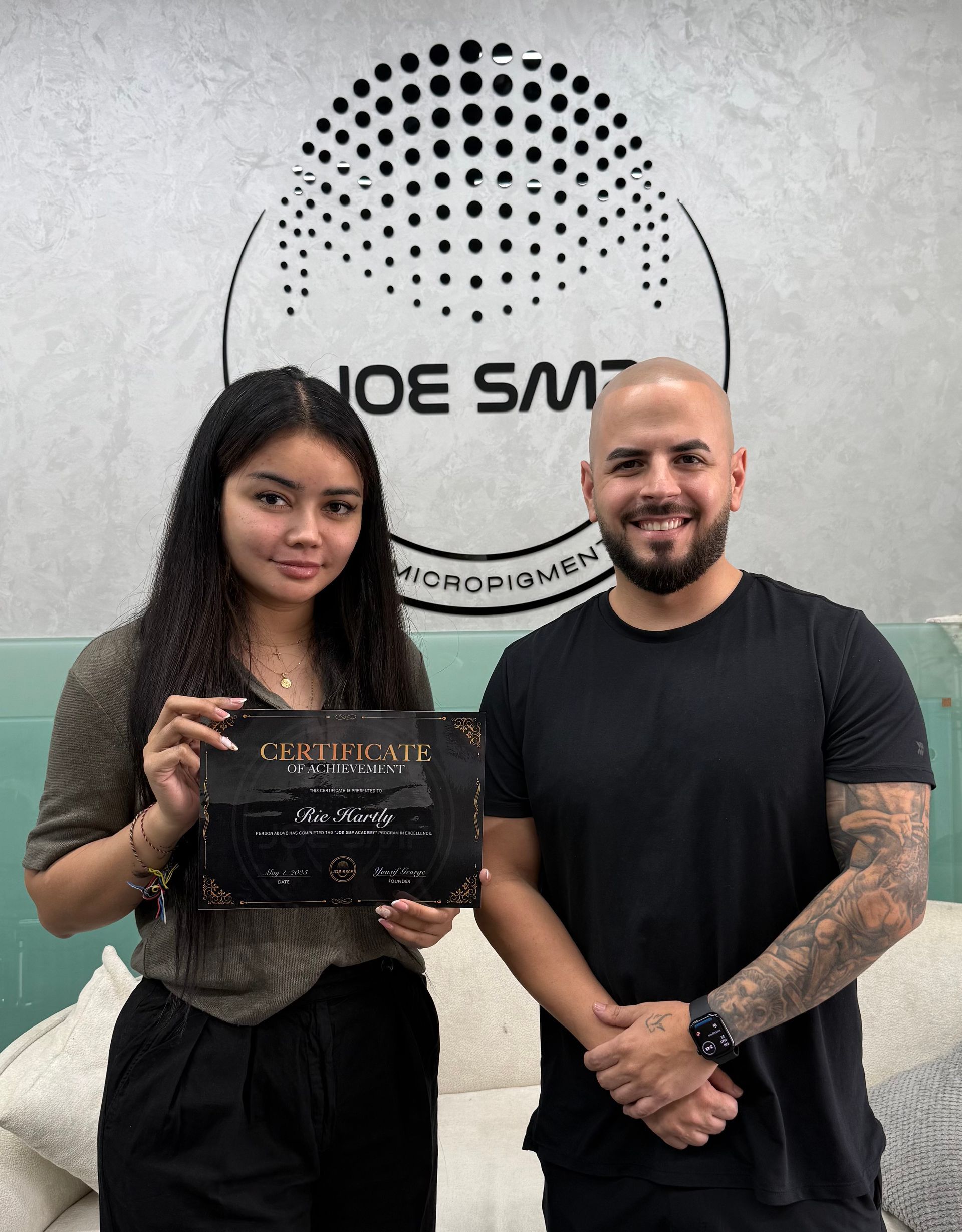 Woman and man holding certificate in front of 