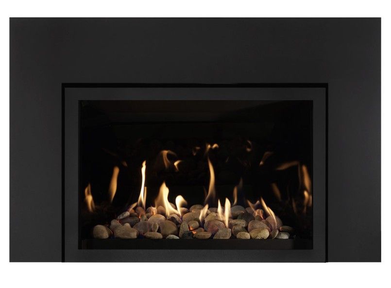 A modern black fireplace with burning flames and decorative white stones.