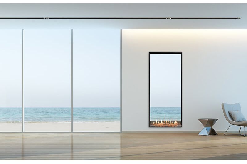 Living room with fireplace, white sofas, and windows overlooking a green forest. Dark blue fireplace, white cabinetry.