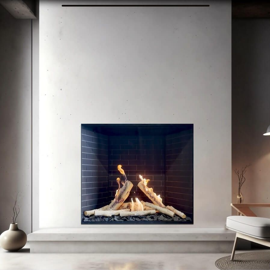 Fireplace with lit flames, set in a stone wall. A marble shelf supports art and decor; a living room setting.
