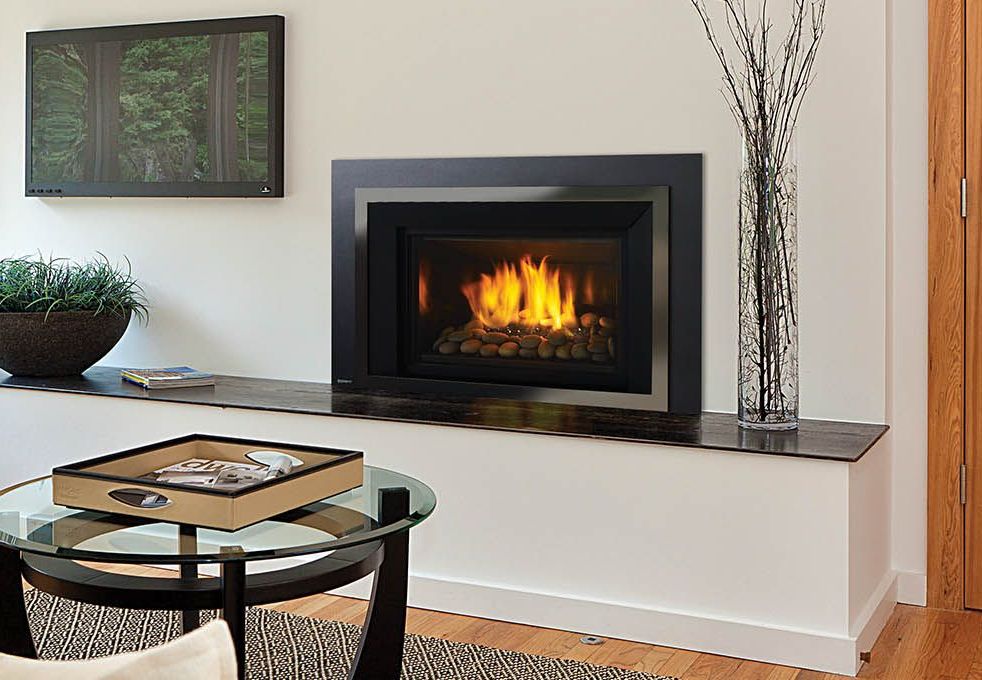 A modern fireplace with a black frame and flames, built into a white wall. A decorative tray and coffee table are in front.