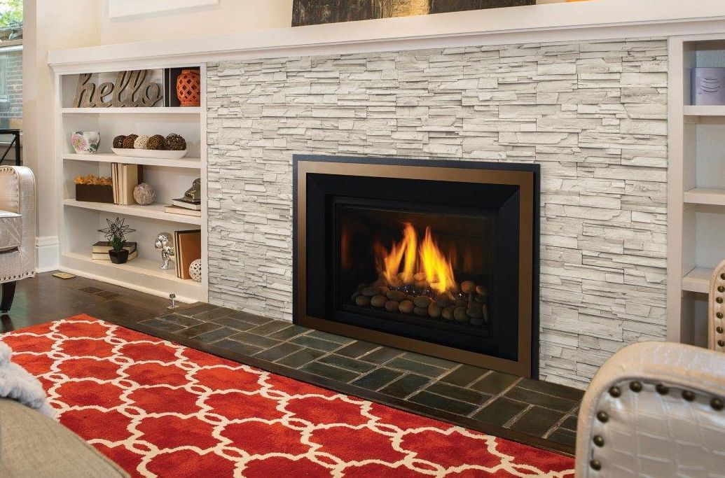 Fireplace with flames in a living room setting, flanked by built-in white bookshelves, and set on a patterned red rug.