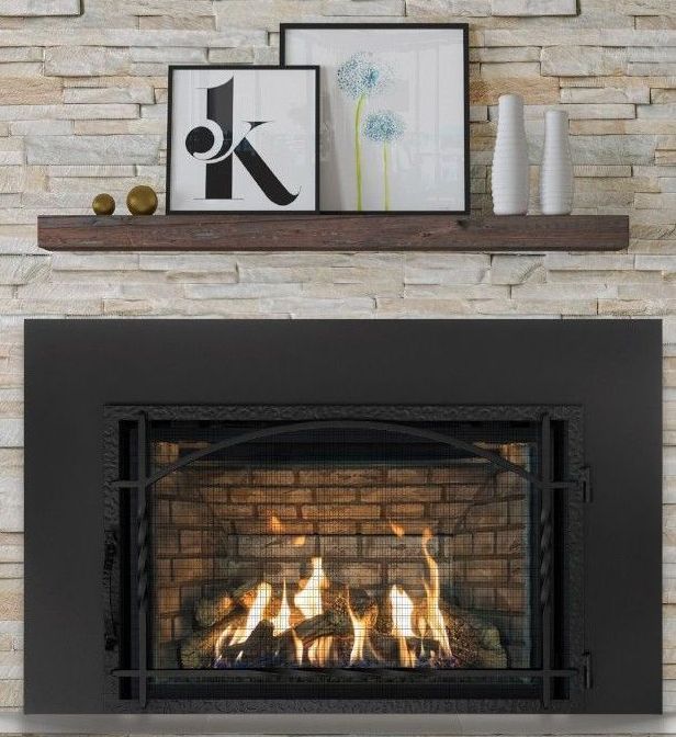 A lit fireplace with a black metal surround. A wooden shelf above holds artwork and decorative vases.