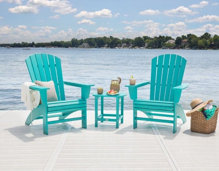 Colorful polywood Adirondack chairs lined up outdoors.