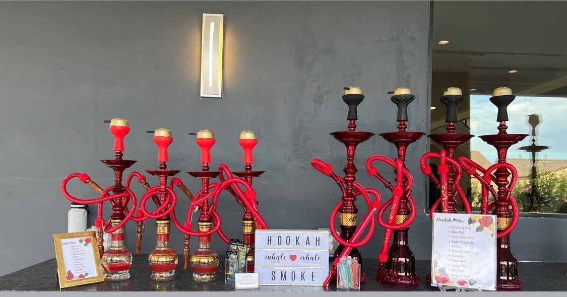 A row of red hookahs sitting on top of a table.