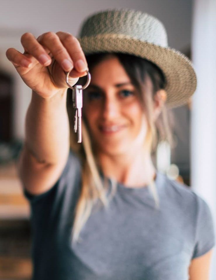 Femme qui tend la main pour donner des clés d'un appartement