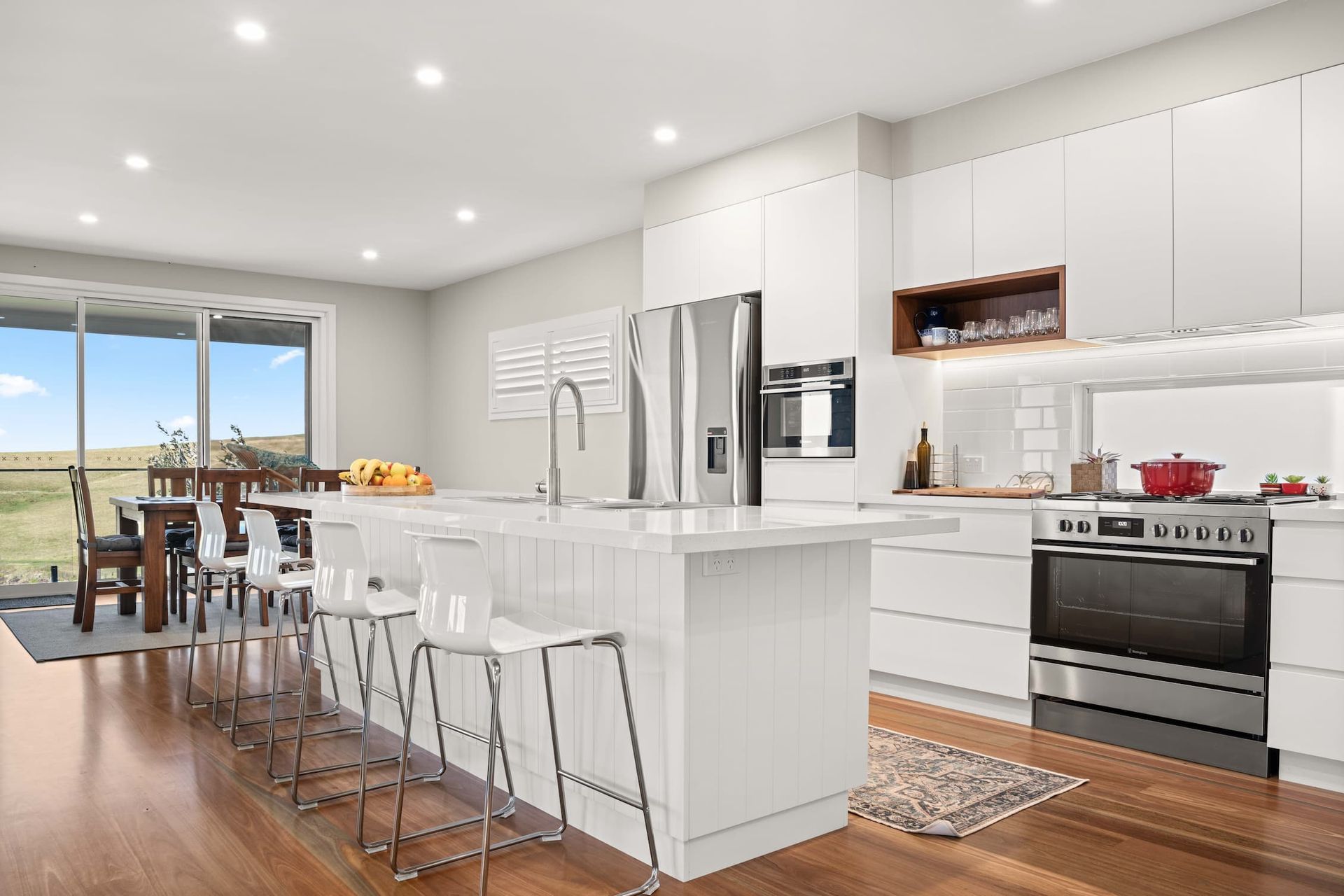 A Modern White Kitchen With Wooden Floors — Ridgeline Building Co In Gerringong, NSW