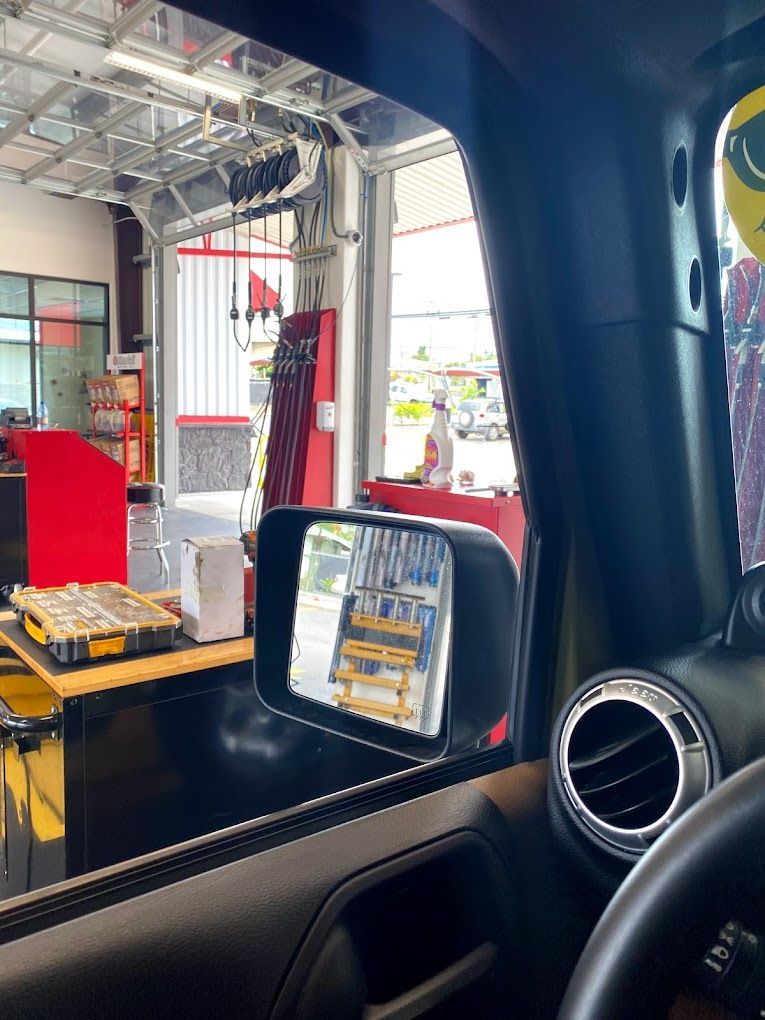 A car is parked in a garage with a rear view mirror.
