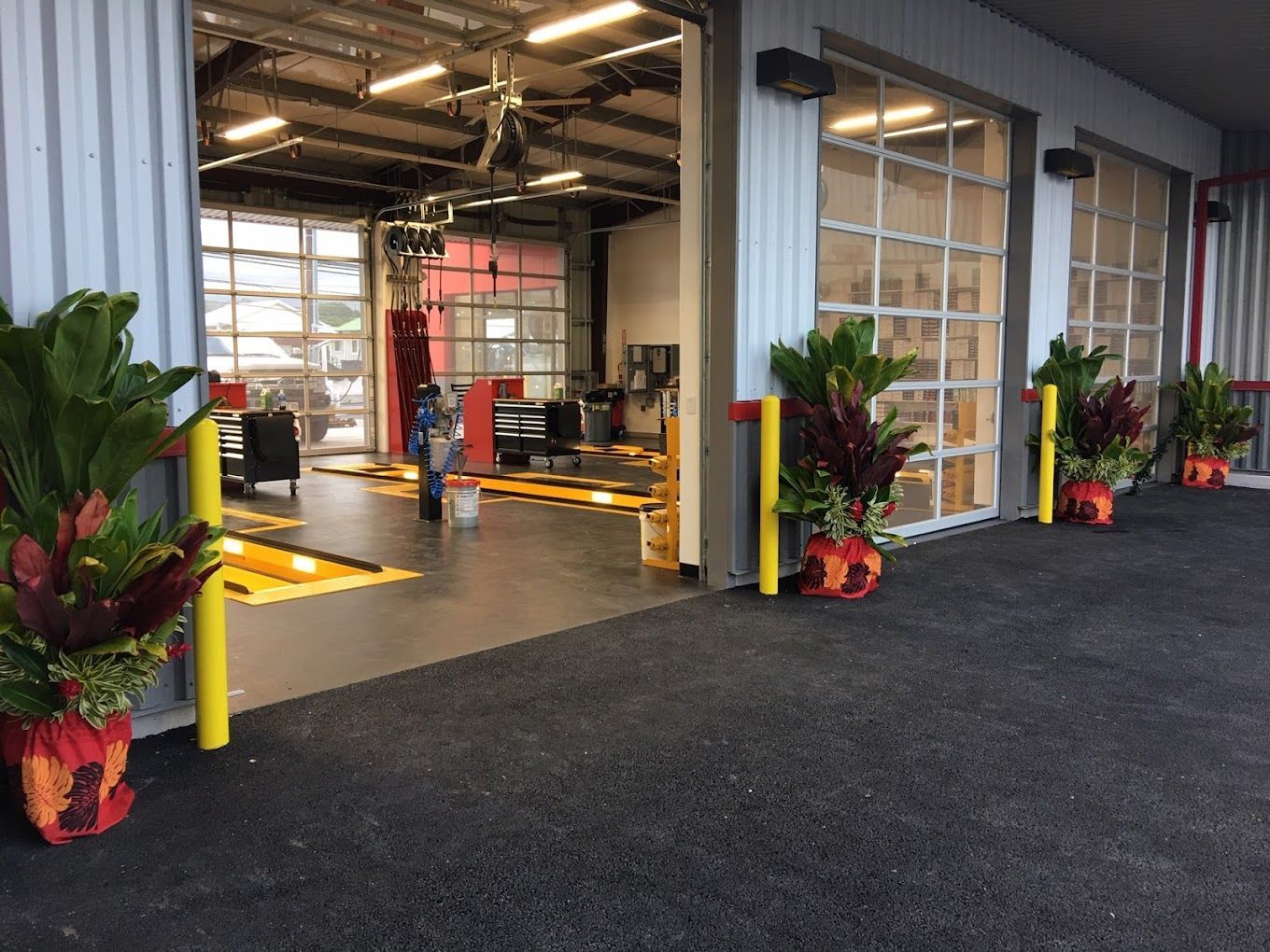 A garage with a lot of potted plants in front of it.