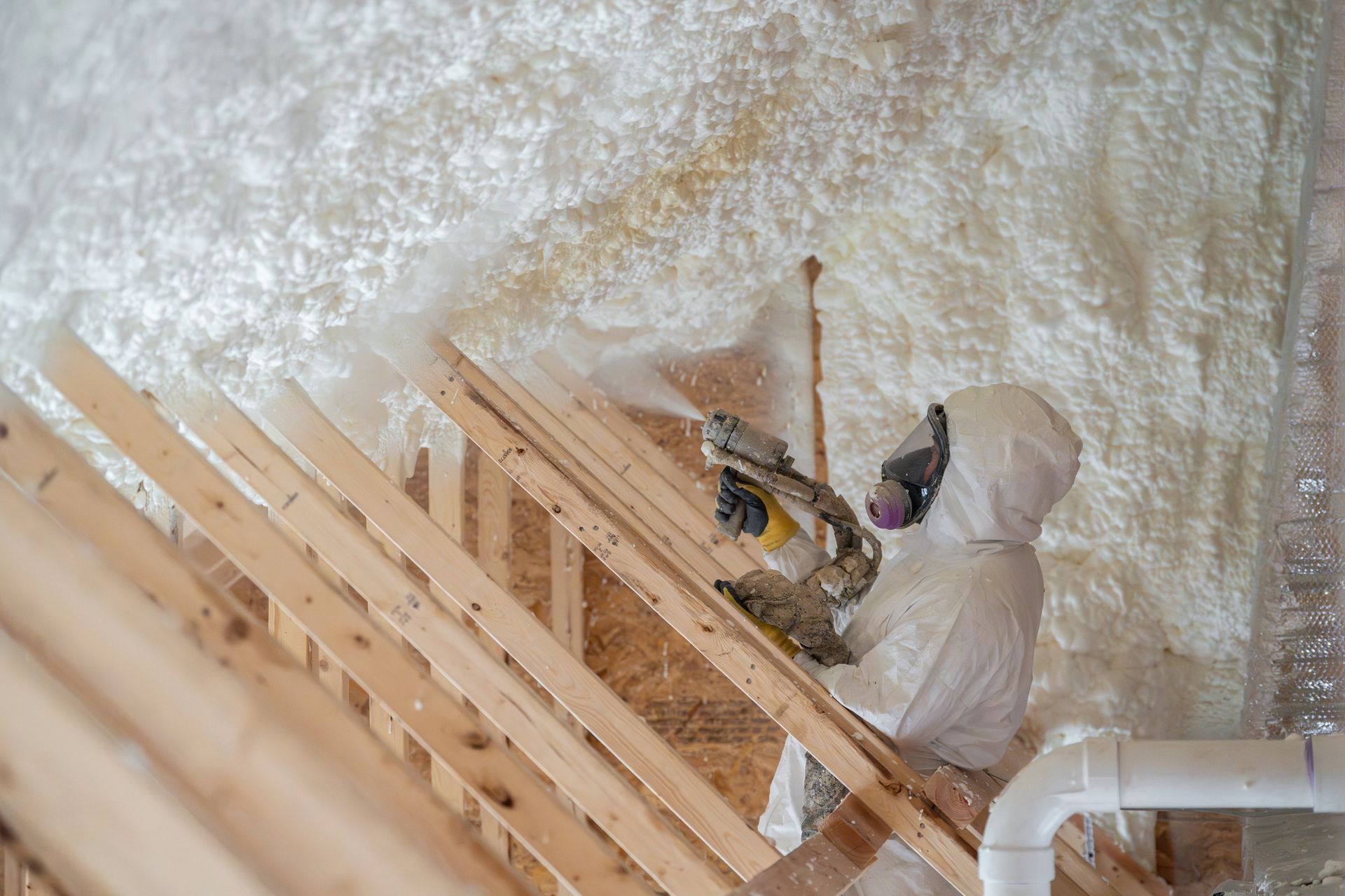 Construction worker spraying house insulation