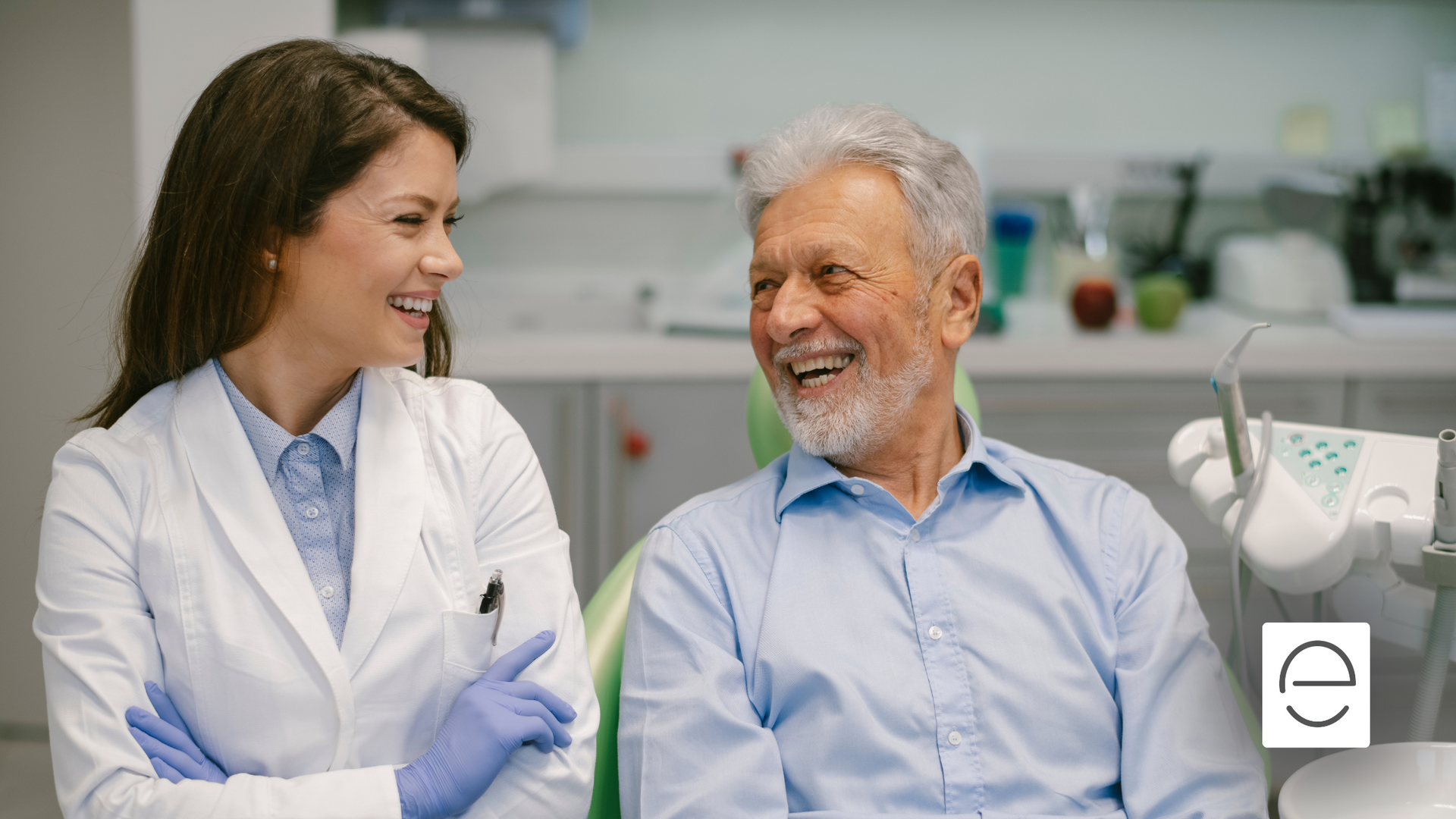 A female dentist is talking to an older man in a dental chair.