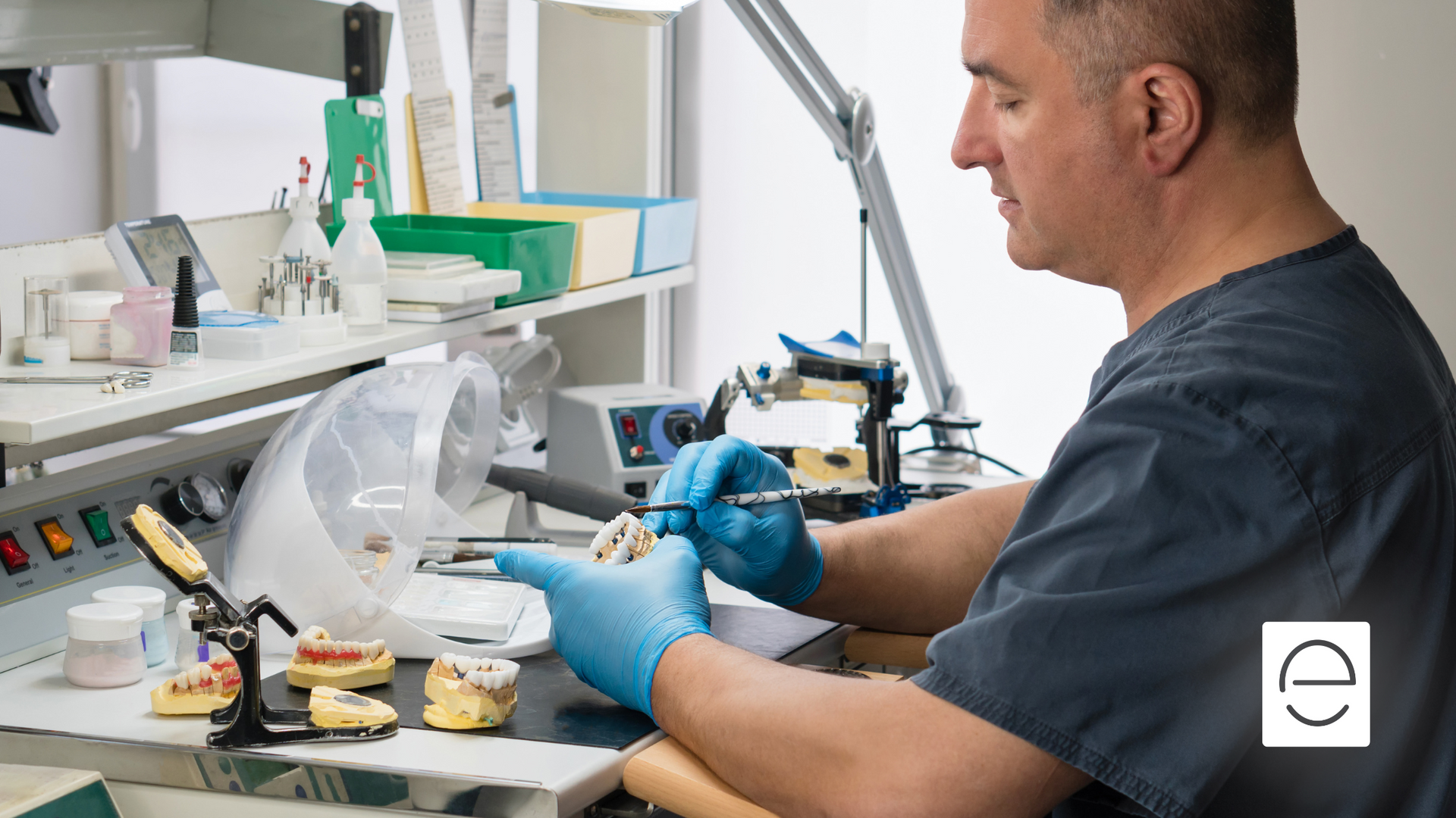 A dentist is working on a denture in a dental office.