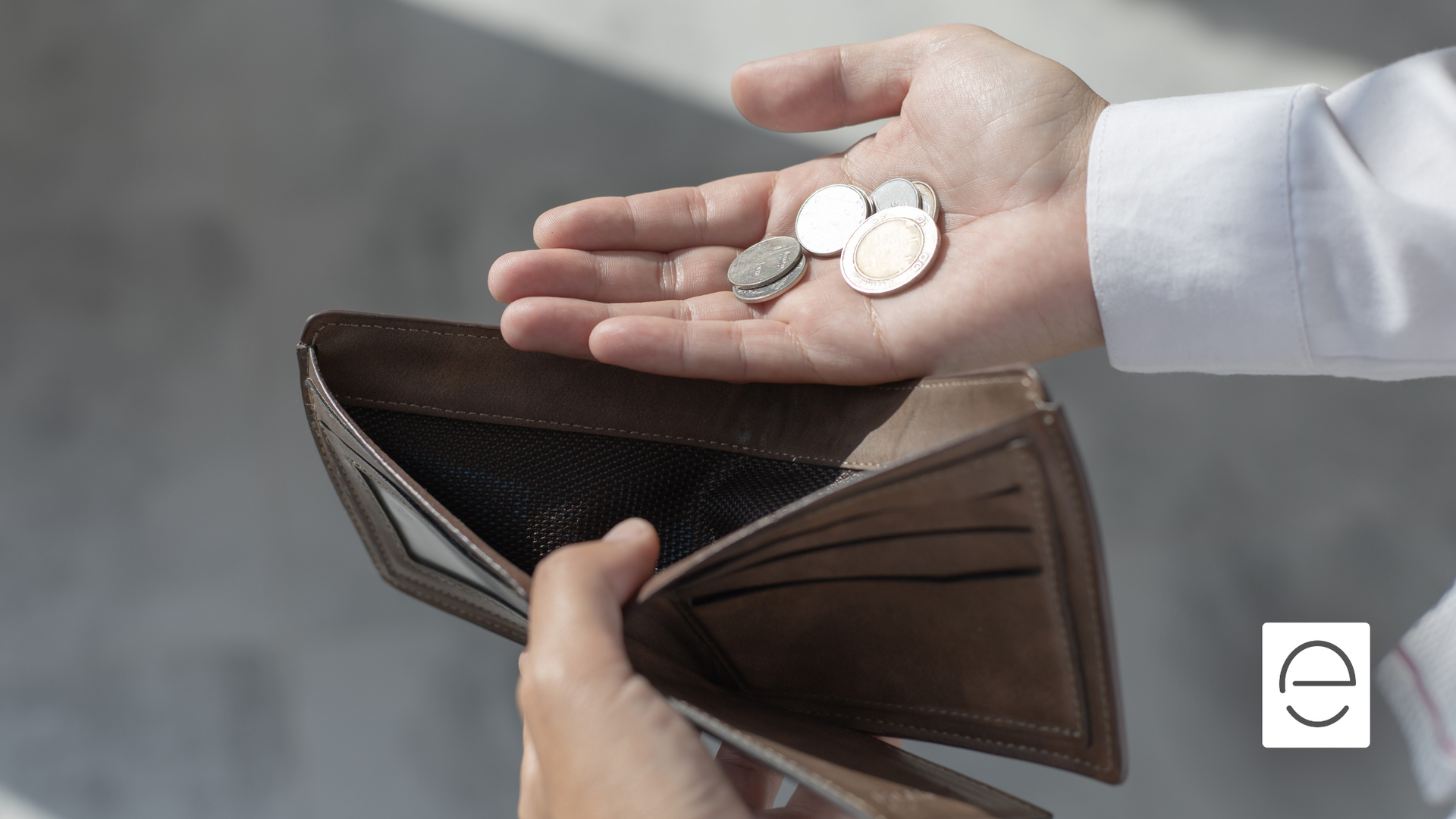 A person is holding a wallet with coins in it.