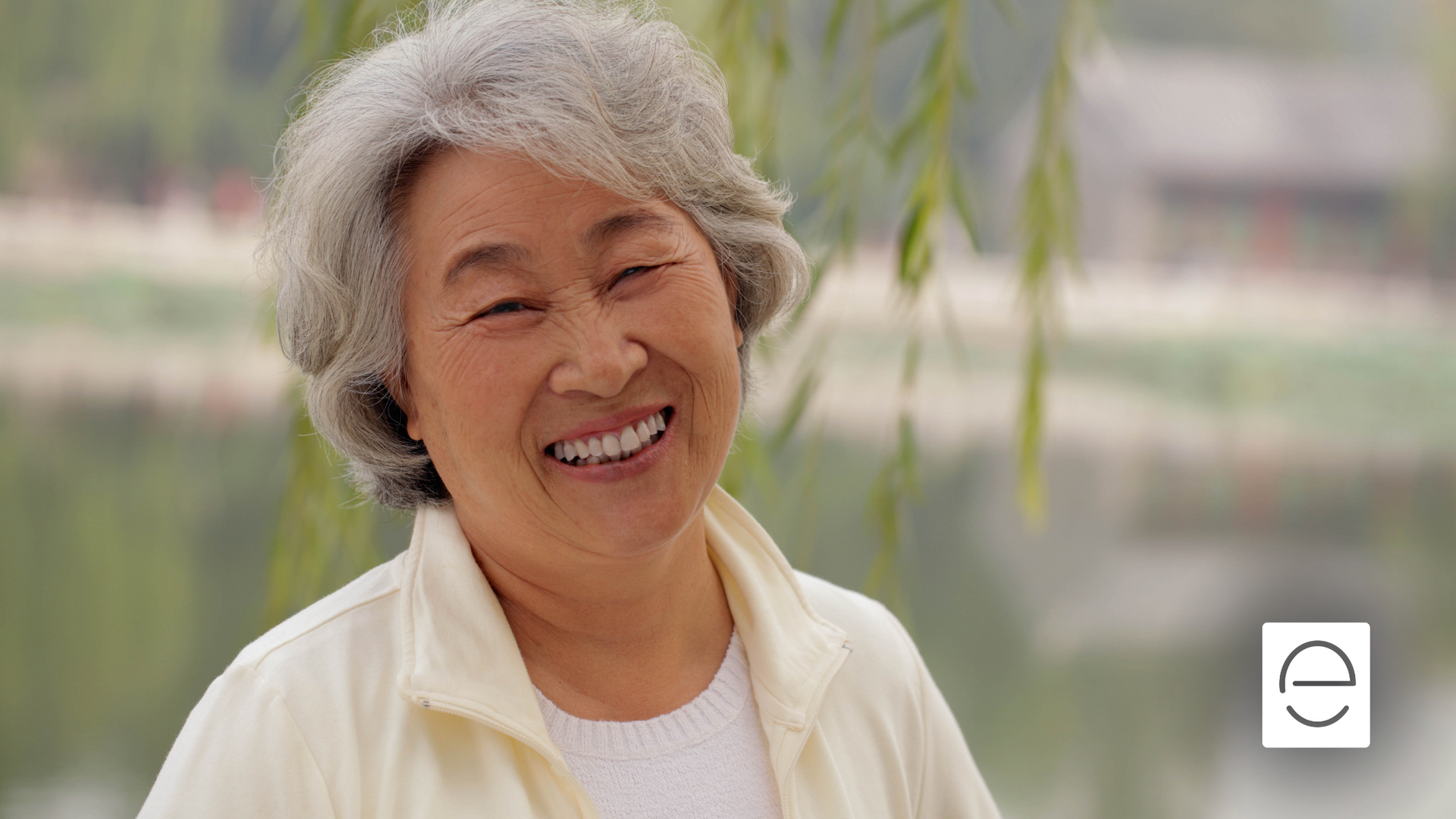 An elderly woman with gray hair is smiling for the camera.